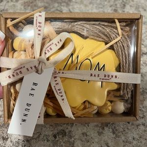 This a cute Rae Dunn sign that says Mom and is on beads. NWT